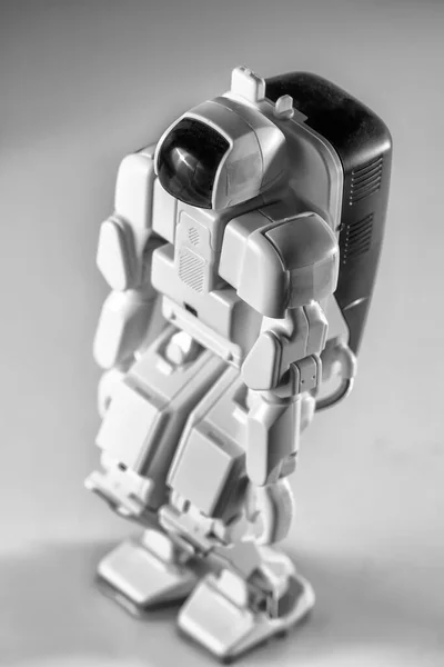 Modern advanced autonomous robot toy isolated on a gray background.