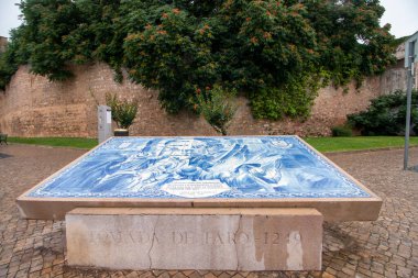 Portekiz 'in Faro şehrindeki ünlü tarihi kale duvarının manzarası. Azulejo sanat eserleri ön taraftaki ünlü tarihi anları tasvir ediyor..