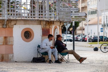 FARO, PORTUGAL - 20 Haziran 2021: İki arkadaş koltuklarda oturup birbirleriyle konuşarak rahatlıyorlar.