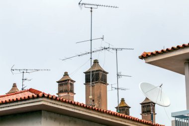 Eski bacaları ve antenleri olan Portekiz evlerinin tipik çatı manzarası.