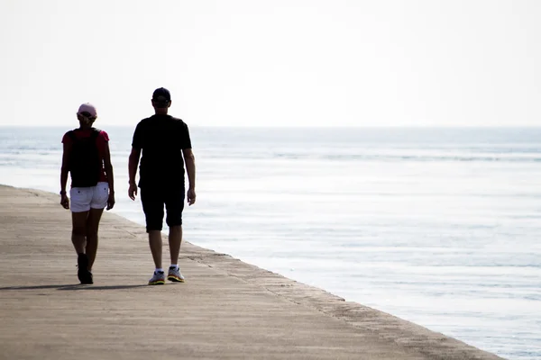 Long pier water breaker with a couple moving around — Stock Photo, Image