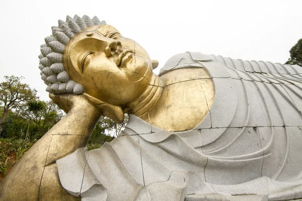 Bir park üzerinde yatan Buda heykeli. — Stok fotoğraf