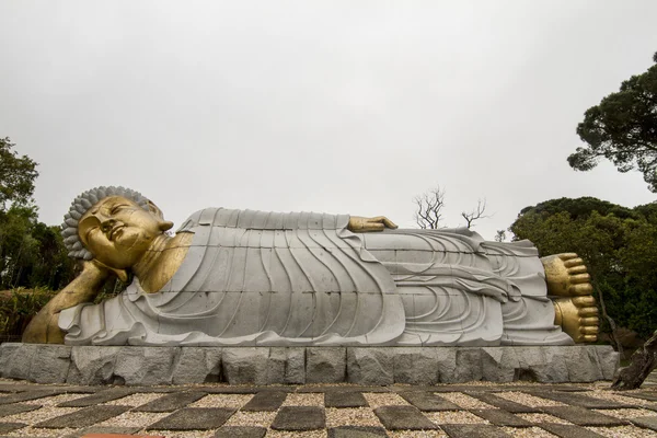 Bir park üzerinde yatan Buda heykeli. — Stok fotoğraf