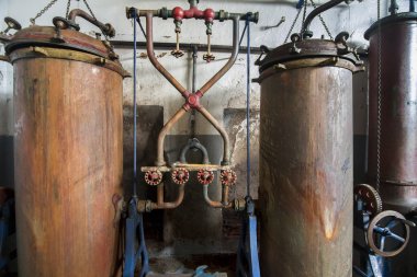 Old distillation tanks for aguardiente (alcoholic beverage) clipart