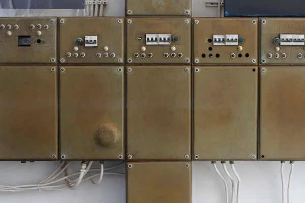 Fila velha de caixas elétricas em uma parede — Fotografia de Stock