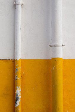 yarısı sarı ve beyaz borular ile boyalı duvar.