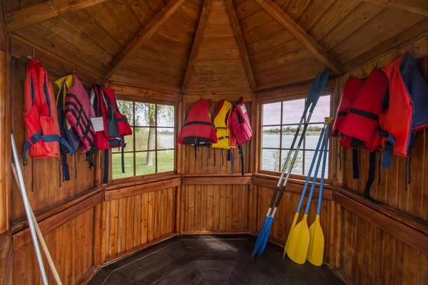 Wooden boat house with life jackets — Stock Photo, Image