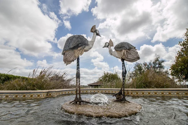 two stone statues of crane birds