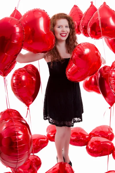 Glad ung flicka mellan röda ballonger — Stockfoto