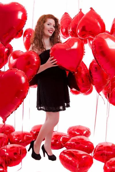Glad ung flicka mellan röda ballonger — Stockfoto