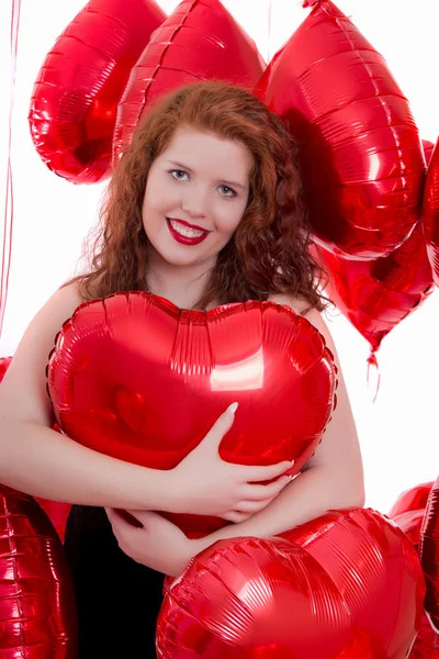 Glad ung flicka mellan röda ballonger — Stockfoto