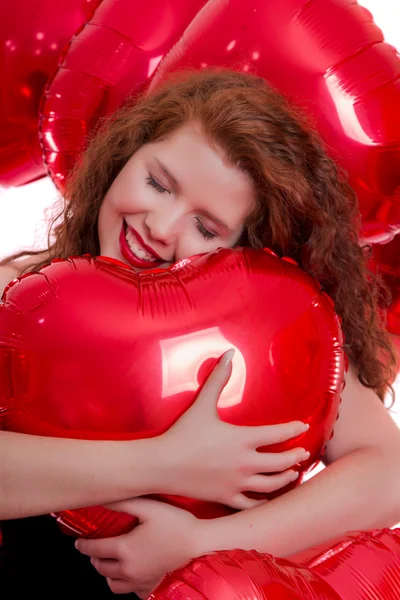 Happy young girl between red balloons — Stock Photo, Image