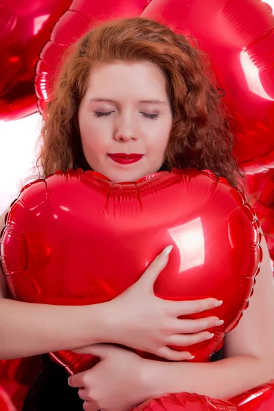 Happy young girl between red balloons — Stock Photo, Image