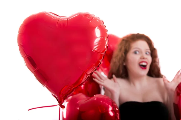 Glückliches junges Mädchen zwischen roten Luftballons — Stockfoto