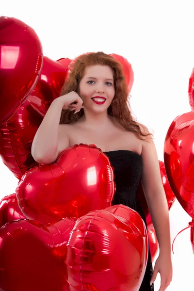 Glückliches junges Mädchen zwischen roten Luftballons — Stockfoto
