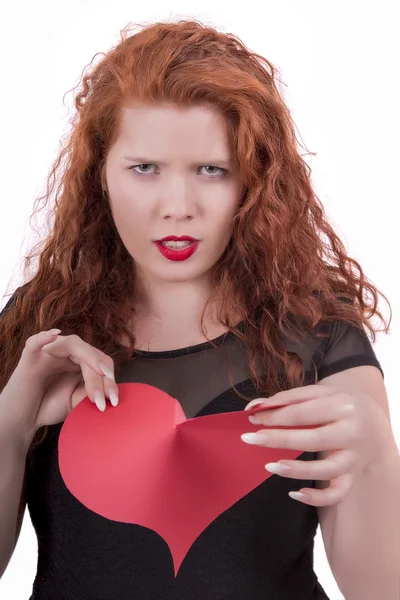 Menina irritada rasgando um coração vermelho — Fotografia de Stock