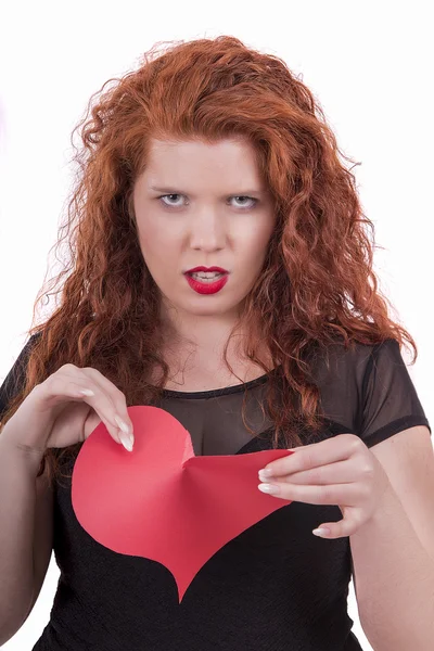Rozzlobený mladá dívka trhání červené srdce — Stock fotografie