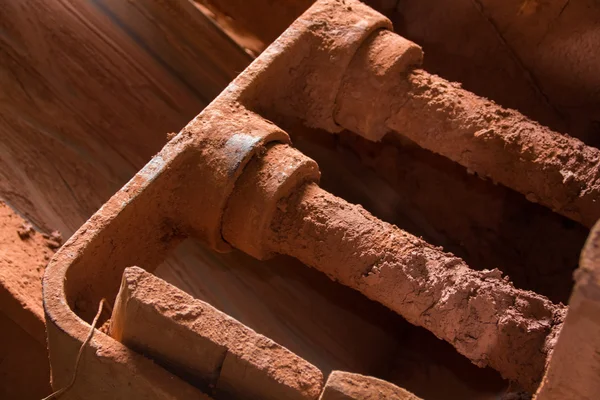 Gear and mechanisms to broken red dirt to create clay mud — Stock Photo, Image