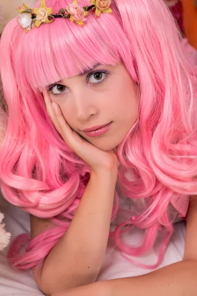 Mladá dívka v ložnici s růžovou parukou — Stock fotografie