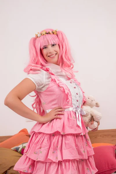 Chica joven en un dormitorio en un vestido lindo rosa — Foto de Stock