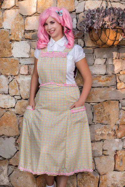 Young girl with a pink wig posing as a housewife. — Stock Photo, Image