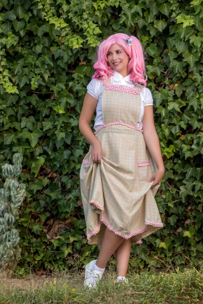 Jovem com uma peruca rosa posando como no parque — Fotografia de Stock