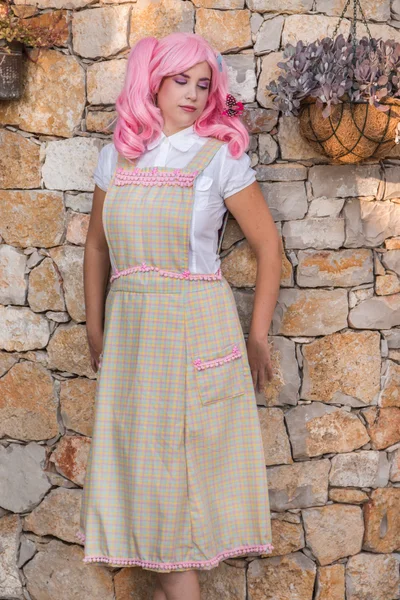 Jovem com uma peruca rosa posando como uma dona de casa . — Fotografia de Stock