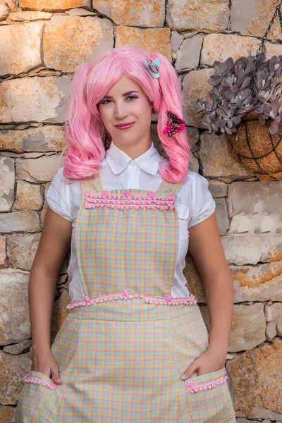 Young girl with a pink wig posing as a housewife. — Stock Photo, Image