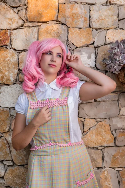 Giovane ragazza con una parrucca rosa in posa come casalinga . — Foto Stock