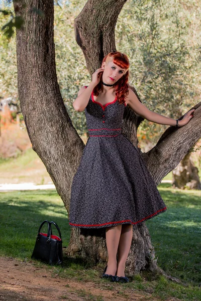 公園でポーズ単純泉ドレスを持つ若い女性 — ストック写真
