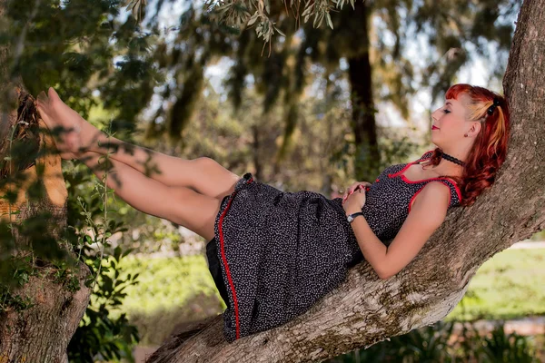 Ung kvinna med en enkel våren klänning poserar på parken — Stockfoto