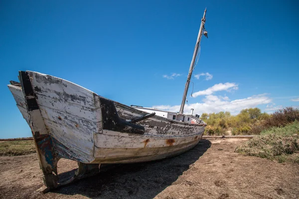 Barco abandonado en la vegetación en las dunas de arena — Foto de Stock