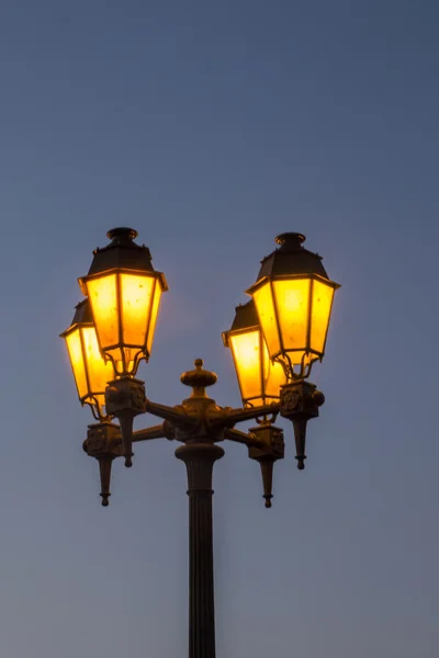 Típica farola europea encendida al atardecer —  Fotos de Stock