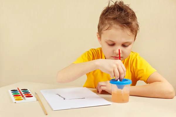 Young artist in yellow shirt painting colors