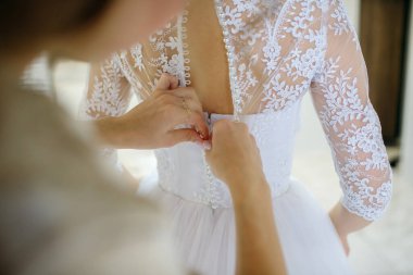 Düğün gününde, anne kızının gelinliğini giymesine yardım eder. Genç ve güzel bir kadın kocasıyla evlenmeye hazırlanıyor.