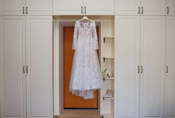 Ein Weißes Brautkleid Hängt Einem Kleiderbügel Neben Den Hochzeitsaccessoires Schuhen — Stockfoto