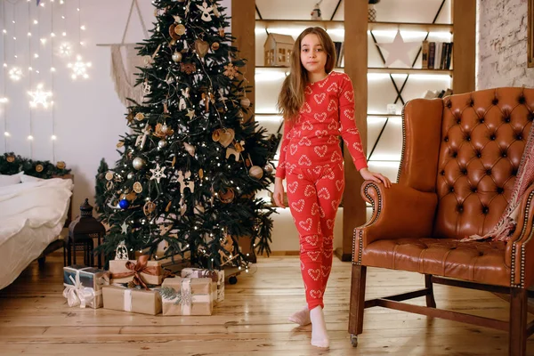 Ein Kleines Mädchen Roten Pyjama Steht Neben Einem Geschmückten Weihnachtsbaum — Stockfoto
