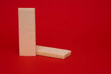 Kırmızı arka planda waffle kurabiyeleri. Kahve ya da çay için lezzetli tatlı. Metin için boş alan. Waffle çocuklar ve yetişkinler için bir lezzettir.