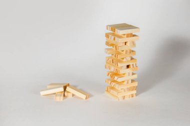 Beyaz arka planda tahta masa oyunu. Denge ve matematiğin önemli olduğu bir oyun. Tahta blok kulesi ve metin için boş alan