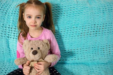 At kuyruklu küçük bir kız mavi bir koltukta oturuyor, elinde bir oyuncak ayı tutuyor ve çok üzgün. Çocuk ağlamaya başlar ve gözyaşlarını tutar. Çocuk yetiştirmek ya da katı ebeveynler