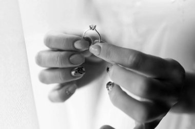 Düğün gününün siyah beyaz fotoğrafı. Güzel manikürlü gelin elleri bir elmas yüzük tutuyor. Her kadın için mutlu ve heyecanlı bir gün. Metin için boş alan