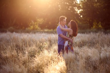 Bir adam ve bir kadın gün batımında tarlada yürüyor ve sarılıyorlar. Sevgi dolu bir çift geceyi dışarıda geçirir. Genç bir esmer kadın uzun bir elbise ve ekose gömlekli bir adam giyiyor.