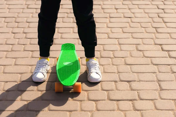 一个少年学习骑滑板或便士板 腿和滑板靠拢了 自由的文字空间 骑一个小滑板对发展儿童的协调与平衡是有益的 — 图库照片
