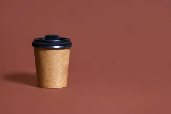 茶色い背景のカフェ用の使い捨てコーヒーカップ テキスト用の場所とエココーヒーカップの茶色の段ボールモックアップ 使い捨てプラスチックと紙のホットドリンクテンプレート — ストック写真