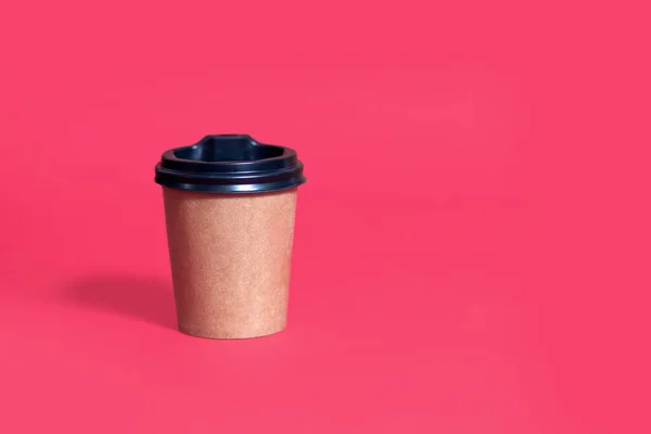 テキストのための場所と赤の背景に蓋付きの段ボールコーヒーカップ 現代のコーヒーショップで生態系のパッケージの概念 使い捨てコーヒーカップ — ストック写真