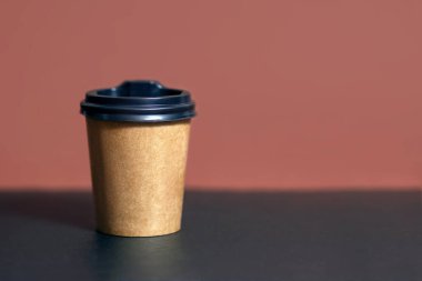 Bar masasındaki kafe için tek kullanımlık kahve fincanı. Kahverengi eko kahve fincanının kartondan maketi. Tek kullanımlık Plastik ve Kağıt Sıcak İçecekler Şablonu