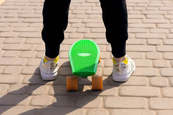 一个少年在街上学习骑滑板或便士板 腿和滑板靠拢了 骑在白板上有助于你的孩子发展协调与平衡 — 图库照片