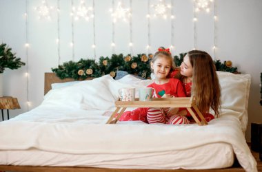 Pijamalı rahibeler yatakta oturur ve köknar dalları ve çelenklerle süslenmiş güzel bir Noel odasında sıcak kakao içerler. İki kız yeni yıl ve Noel tatillerinde sohbet ederken eğleniyor.