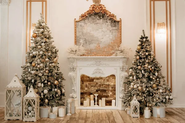 Koridorun kenarında iki süslü Noel ağacı ve ortada da bir şömine. Zengin geleneksel ev dekoruyla Noel ve Yeni Yıl. Kutularda mumlar ve Noel oyuncakları.