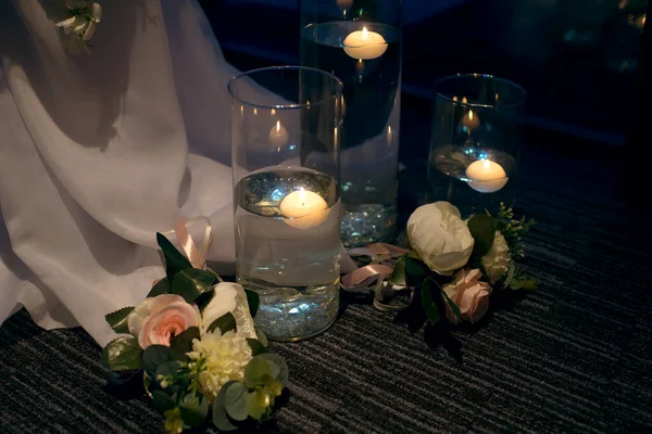 The restaurant is decorated with candles and flowers. Evening dinner and stylish decor on the floor near the tables in the form of floating candles. Free space for text